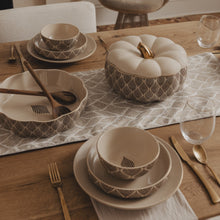 Stoneware soup tureen with cream lid and dark leaf pattern on dining table