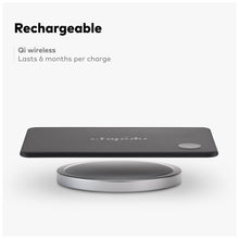 Thin black Chipolo CARD sitting on a round wireless charging base