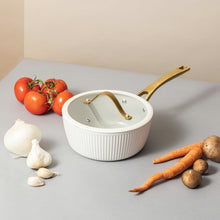 White ribbed non-stick saucepan with gold handle and white lid
