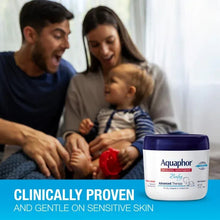 Aquaphor Baby healing ointment jar in view while parents hold a baby
