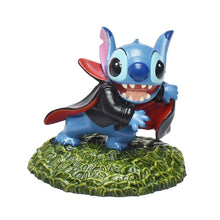 Disney Stitch figure in a black vampire cape on a textured green base