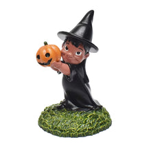 Witch figure in a black robe and pointed hat holding a jack-o'-lantern