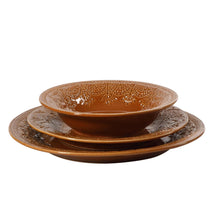 Caramel ceramic bowl with lace-pattern rim, paired with matching embossed plates