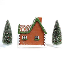 Prelit gingerbread house decoration with two snowy pine trees