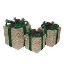 Three gold lighted gift boxes with green ribbon details and pine-and-berry decorations