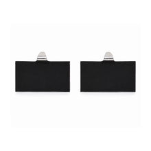 Pair of stocking holder backs with black rectangular pads and silver hooks