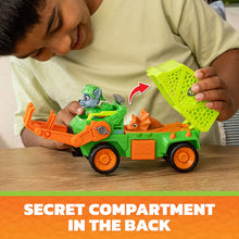 Child playing with green dino rescue recycler truck; secret compartment flap on back
