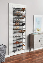 Over-the-door shoe rack holding pairs of shoes on gray mesh shelves.