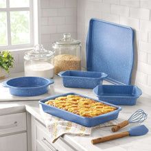 Blue speckled bakeware pans with cornbread in loaf pan, whisk and spatula