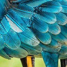 Teal heron statue feather detail with metallic blue embossed pattern.