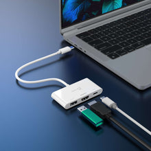 White USB-C hub plugged into laptop ports with visible USB-A connectors