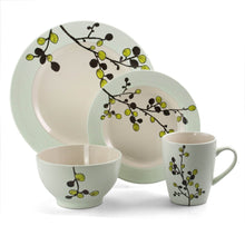 Off-white stoneware dinner plate with green rim and floral branch motif; bowls and mug set