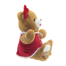 Brown teddy bear plush in red dress with green buttons and white edging, posed on all fours