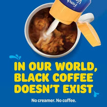 Coffee creamer bottle pouring into a cup of dark coffee