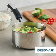 Stainless steel saucepan with black handle, filled with vegetables and side pour spout