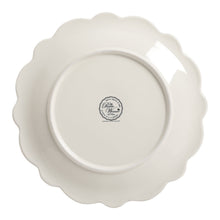 White scalloped dinner plate with round base and logo medallion