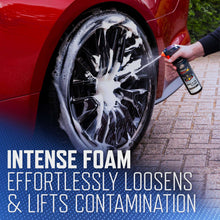 Car wheel being sprayed with foam tire cleaner from a handheld spray bottle