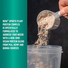 Plant protein powder: measuring scoop of beige powder over clear tub