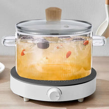 Glass cooking pot with lid and two handles, cork knob, on electric hot plate