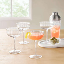 Clear scalloped cocktail glasses with orange drinks and garnish, set of four