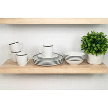 Ceramic dinnerware set with stacked plates, bowls, and mugs on display