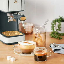White slim espresso machine with cup of espresso and milk frothing pitcher