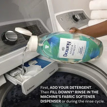 Downy rinse-and-refresh bottle pouring into washing machine fabric softener dispenser