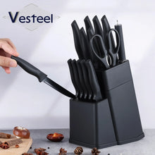 Hand holding a black knife while displayed above a black knife block set