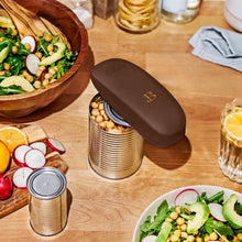 Chocolate-brown automatic can opener positioned on an opened can