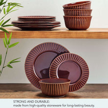 Red stoneware dinnerware set with stacked plates and bowls on display