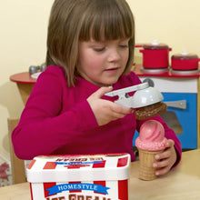 Child using white scoop to stack ice cream cones from the play set box