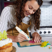 3Doodler Chef 3D pen held in hand, white body with blue indicator dots
