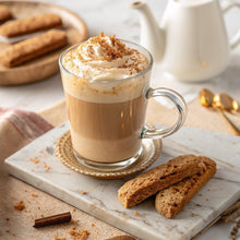 Vanilla caramel latte in a clear glass mug with creamy foam and cinnamon dusting