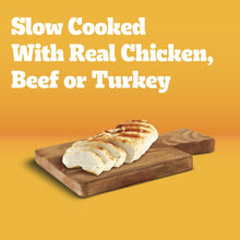 Wet dog food morsels in sauce with chicken, beef, or turkey on a wooden tray