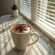 Ceramic mug of latte-brown decaf cafe-style coffee beverage with foam.