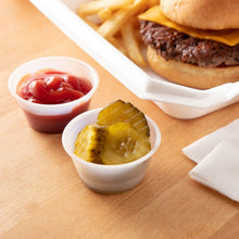 Translucent plastic portion cups with pickles and red sauce, disposable meal prep cups