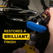 Drill with blue polishing pad applying scratch remover on a car exterior surface