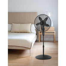 Black oscillating pedestal fan on round base, grille facing forward