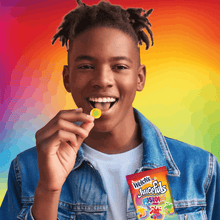 Child holding a Welch's Juicefuls Fusions fruit snack pouch near mouth