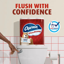 Charmin Ultra Strong toilet paper roll in a red pouch on a bathroom toilet