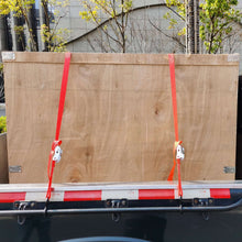 Red tie-down straps with S-hooks on trailer rails with metal buckle end fittings