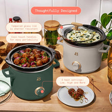 Thyme green manual slow cooker with black lid, food inside, and porcini taupe unit beside it