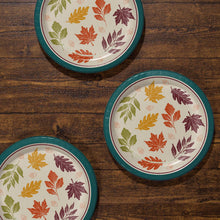 Three teal-rimmed paper plates with multicolor autumn leaf designs