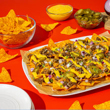 Tortilla chips with cheddar dip and salsa, plus jalapeño slices in bowls