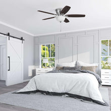 Ceiling fan with frosted light and reversible blades in a bedroom ceiling