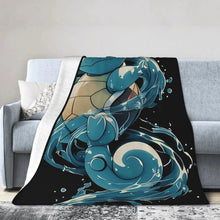 Black flannel throw blanket draped with blue turtle character and teal wave artwork