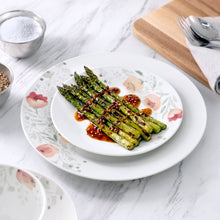 Porcelain double bowl dinnerware set shown with asparagus on a floral poppy plate