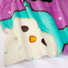 Close-up of purple fleece blanket with white plush animal face and teal details