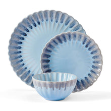 Stacked blue stoneware plates with scalloped rims and a matching bowl