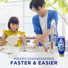 Dish soap bottle on countertop while washing dishes with a sponge